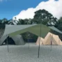 在碎石營地上搭建的軍綠色大型六角天幕，背景可見山區植被與淡黃色隧道帳篷，展示台灣露營常見的遮陽天幕佈局。